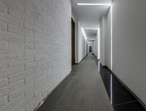 corridor with white brick wall and natural stone floor