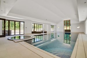 pool with jacuzzi and tall white ceilings and big windows