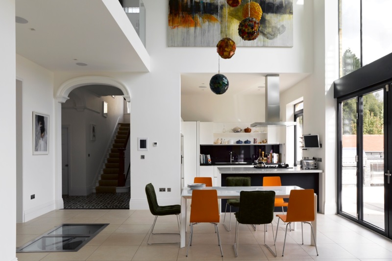 dining area with tall ceiling and statement light feature over dining table